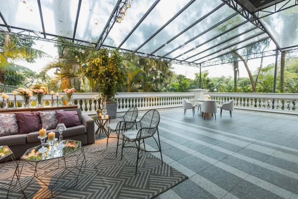 Terraço com cobertura de vidro e estrutura metálica sobre área de estar