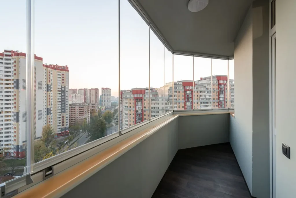 Varanda de apartamento fechada com vidro em sistema retrátil sem montante, com vista para a cidade