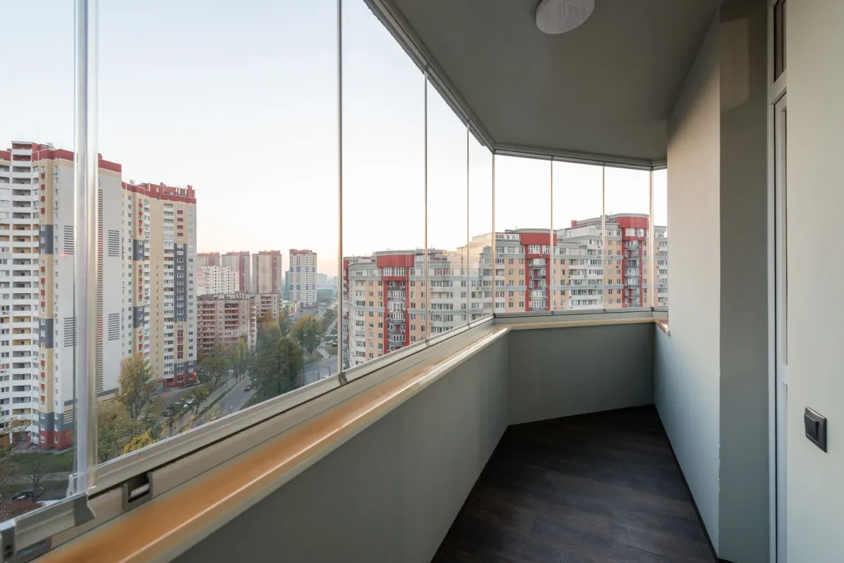 Varanda de apartamento fechada com vidro em sistema retrátil sem montante, com vista para a cidade