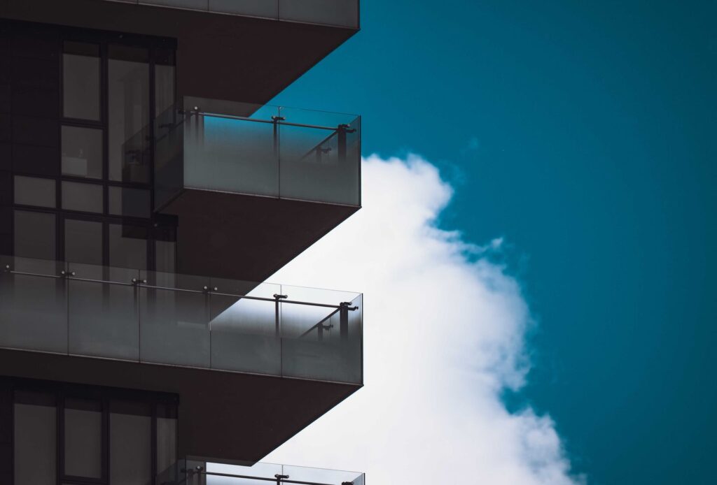 Sacadas de edifício com guarda-corpo de vidro fixado por botões de inox