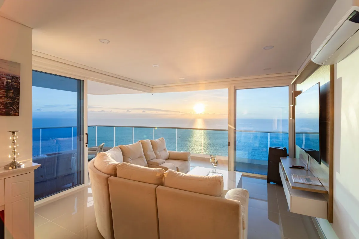 Sala com painel de vidro e vista para o mar, esquadrias sob medida em Macaé